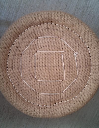 Piquage d’un tabouret de piano rond, vu du dessus.