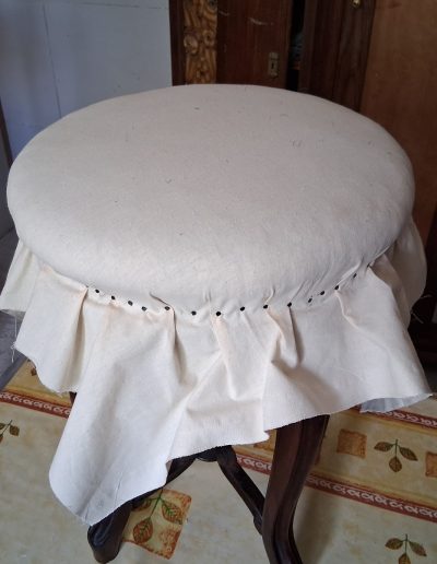 Toile blanche fixée sur un tabouret de piano rond.